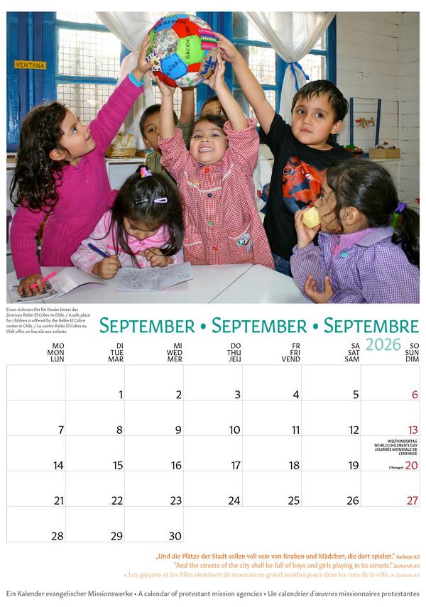 Oben auf dem Kalenderblatt ist das Motiv für den Monat September. Auf dem Bild sind sieben Kinder im Vor- und Grundschulalter zu sehen, die in einem Raum an einem Tisch sitzen und stehen. Die Kinder halten gemeinsam einen bemalten Ball in die Luft, der die Erde darstellen soll, einige Kinder gucken in die Kamera. Auf dem Tisch liegen Malsachen, im Hintergund hängt an der Wand ein Regal mit Spielzeugkisten mit Bauklötzen o.ä. drin. Auf der unteren Hälfte des Blattes befindet sich das Kalendarium für den Monat September 2026. © Foto: Jürgen Schübelin